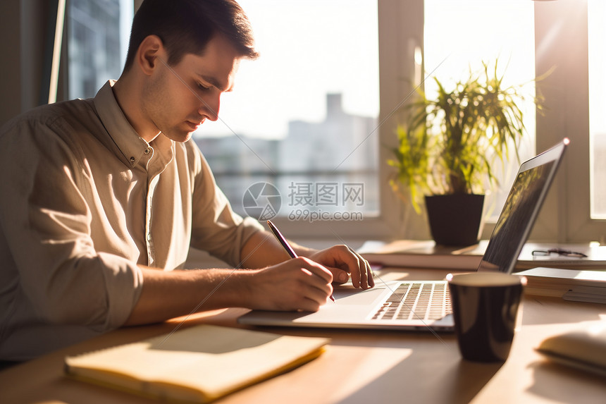 一个男性作家正在用笔写下自己的构思图片