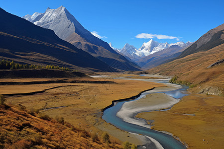 溪流高清素材河流两岸的草地和远处的雪山背景