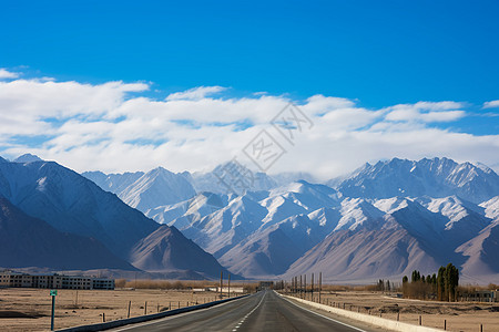 远处的山蓝天下的公路和远处的雪山背景