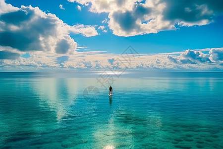 站在绿松石海洋中的桨板上的人图片