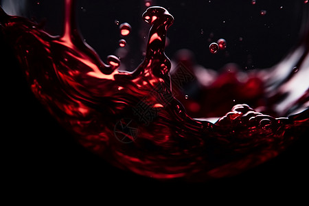 抽象的红葡萄酒飞溅在黑色背景前图片