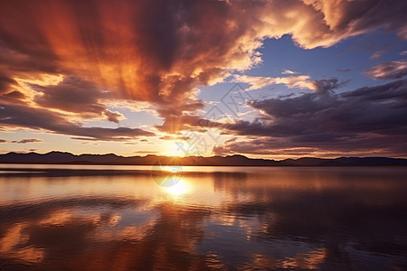 湖面上映射出云彩和日落背景图片