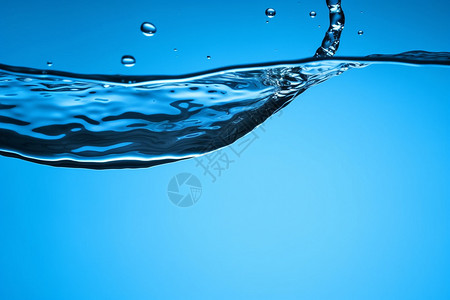 蓝色背景上飞溅的水滴图片