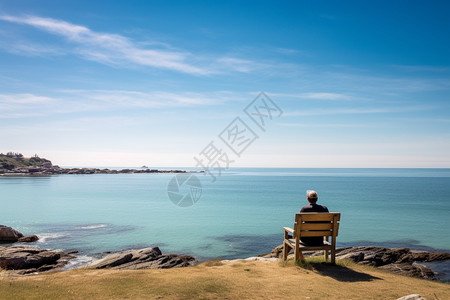 男人坐在海边的椅子上图片