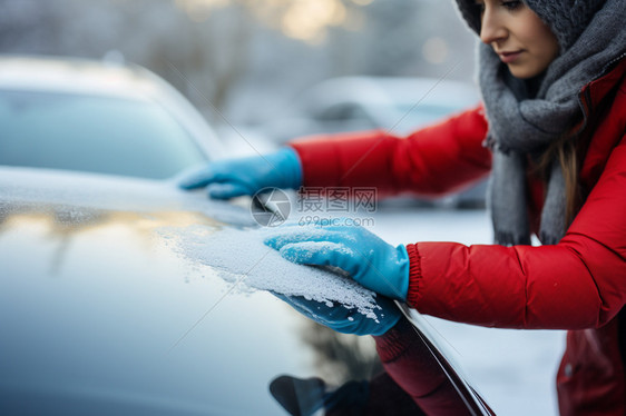 擦去车上积雪的女士图片