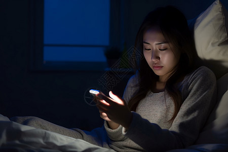 昏暗房间里玩手机的女孩图片