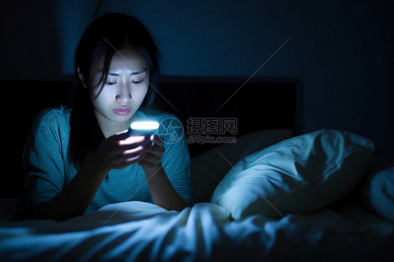夜里床上使用手机的女孩图片