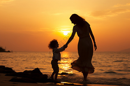 夕阳下沙滩散步的母子图片