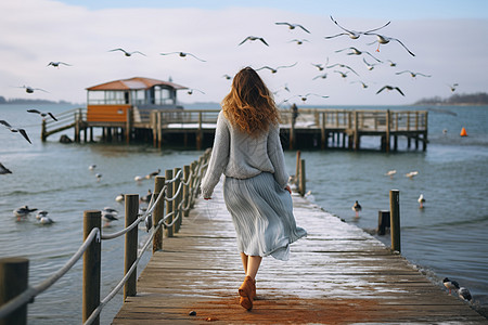 海边海鸥海边码头上散步的女生背景