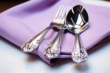 紫色餐巾上的银质餐具图片