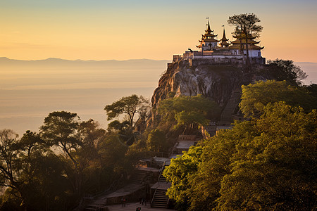 夕阳映照下的山顶佛教建筑图片