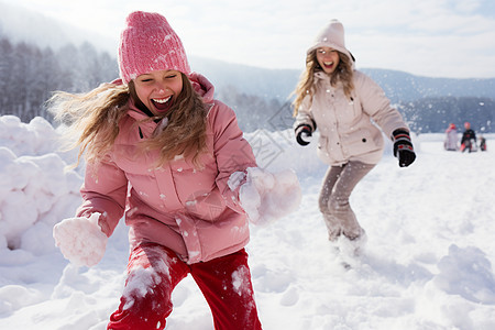 两个女孩在雪地里玩雪球图片