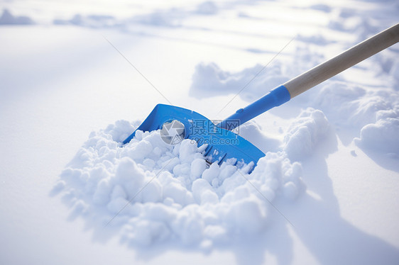 雪地中的蓝色铲子图片