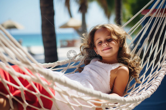 快乐的女孩在沙滩吊床上睡觉图片
