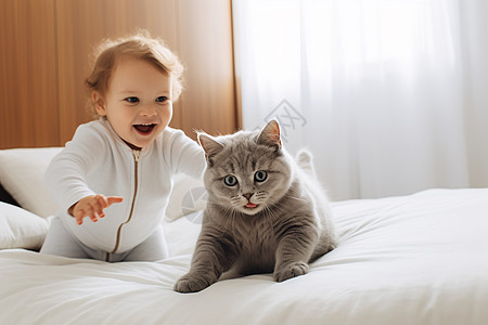 床上和猫咪玩耍的小婴儿图片