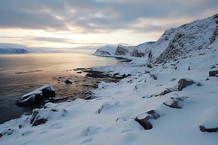 海岸上积雪的山岩图片