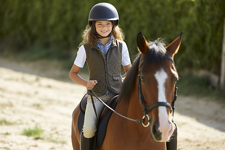 小女孩骑马奔跑在草地上图片