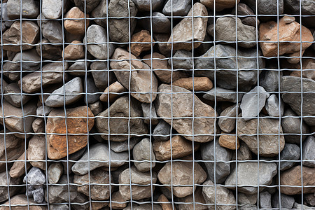 石头堆积在铁网边图片