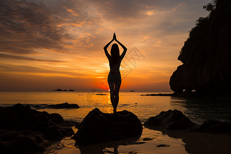 女士站在海边岩石上做瑜伽图片
