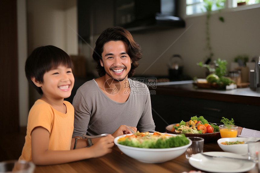 父子在餐桌前享受美食图片