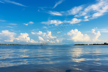 阳光海蓝天白云清澈海水中的小岛背景