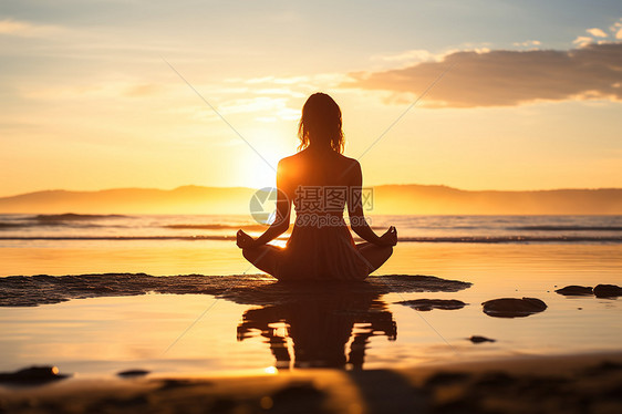 夕阳下女子盘坐于海滩上图片