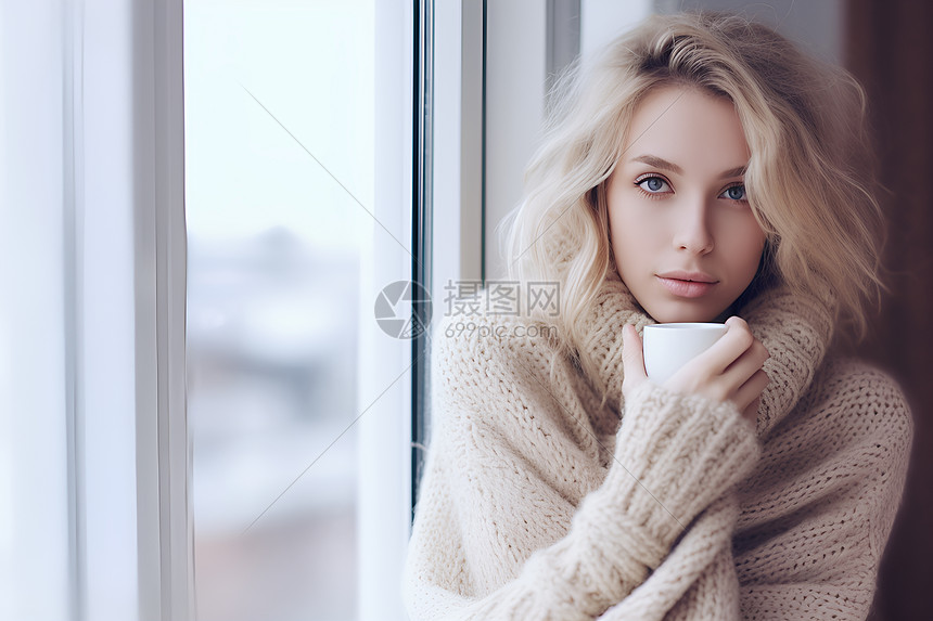 观看窗外冬季雪景的女子图片