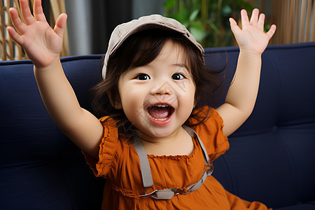 快乐的小女孩在沙发上举起双手图片