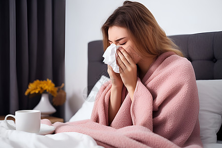 生病的女孩在床上擦鼻涕图片