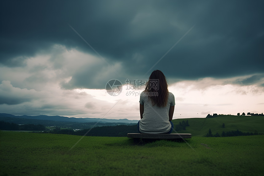 女人独自坐在草地长椅上图片