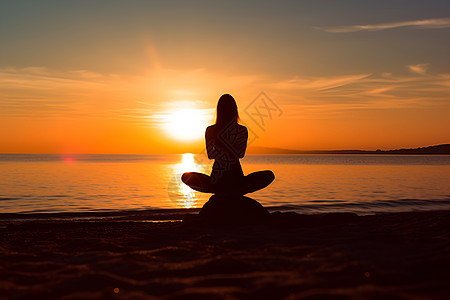 夕阳下海滩上打坐的女人高清图片