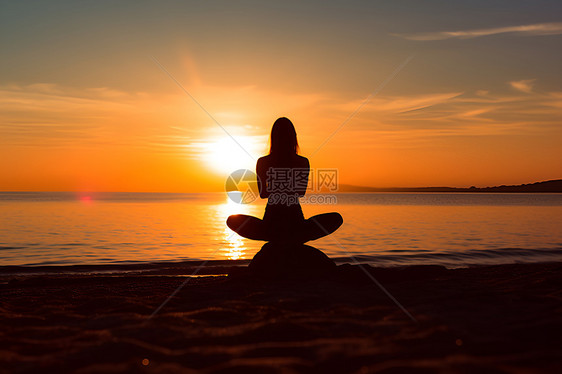 夕阳下海滩上打坐的女人图片