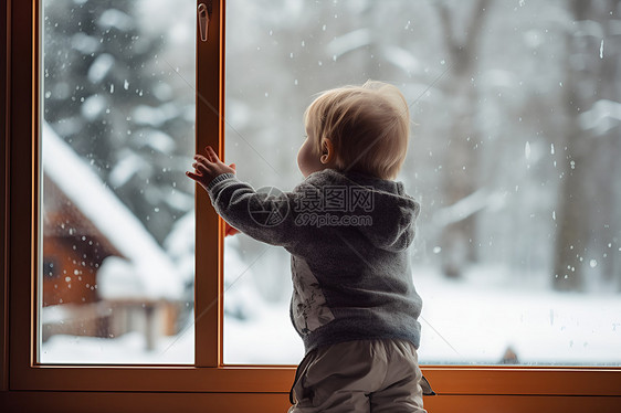 小孩透过窗户望出雪景图片