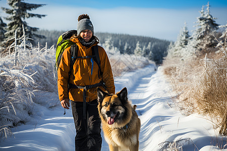冬季雪山中的登山者和宠物狗狗图片