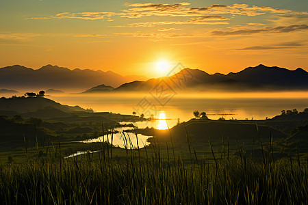 远山草地余晖下的湖泊与远山背景