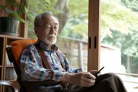 坐在椅子上的男人老年男人坐在椅子上使用平板电脑背景