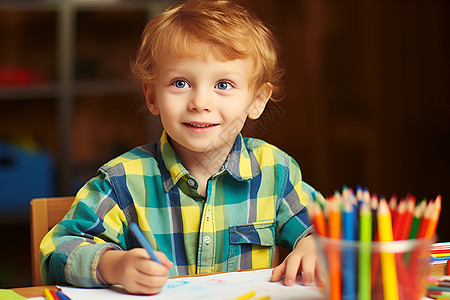 小男孩坐在桌前画画图片