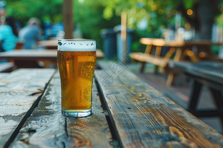 公园木桌旁边放着一杯啤酒图片
