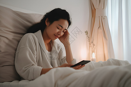 在床上玩手机的女人图片