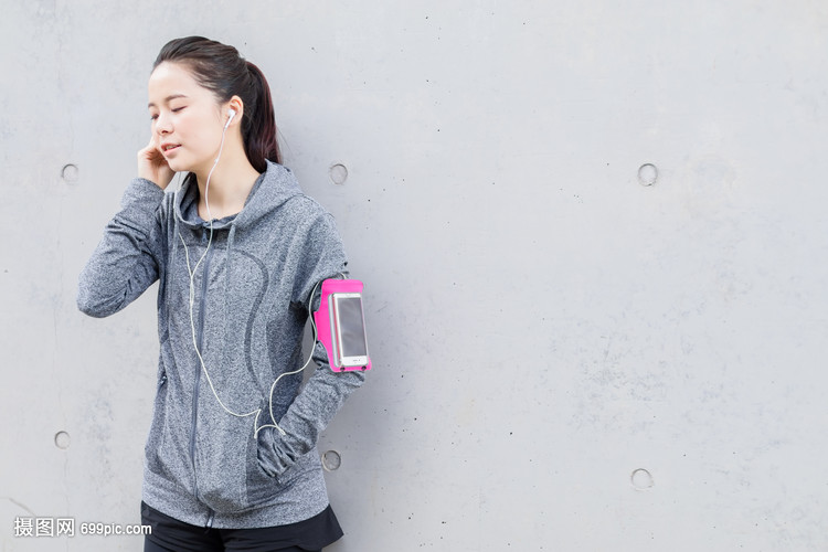 年轻女子健身后听音乐放松