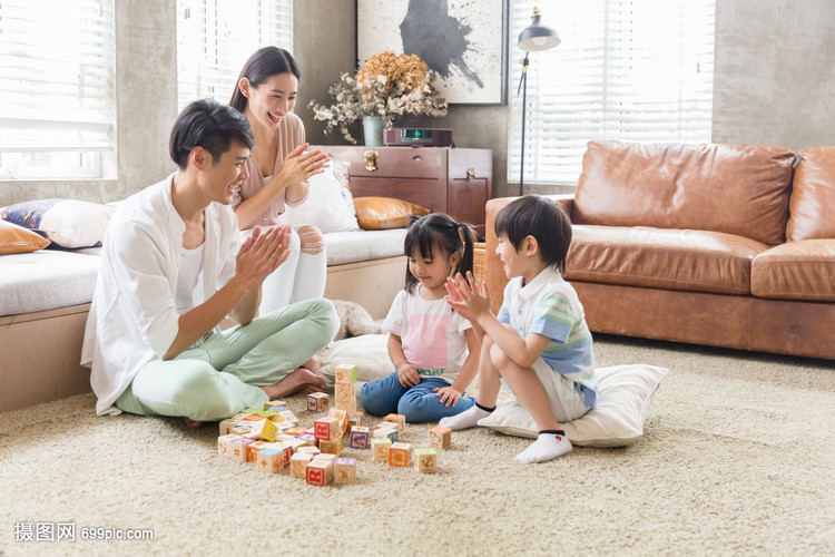 年轻父母陪孩子在家玩游戏
