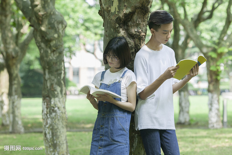 学校林荫道上男女同学下课一起学习看书