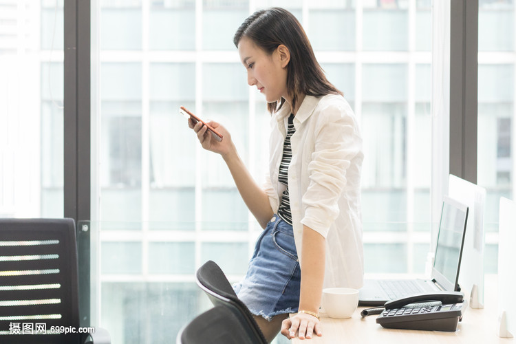 坐着使用手机的办公室女职员