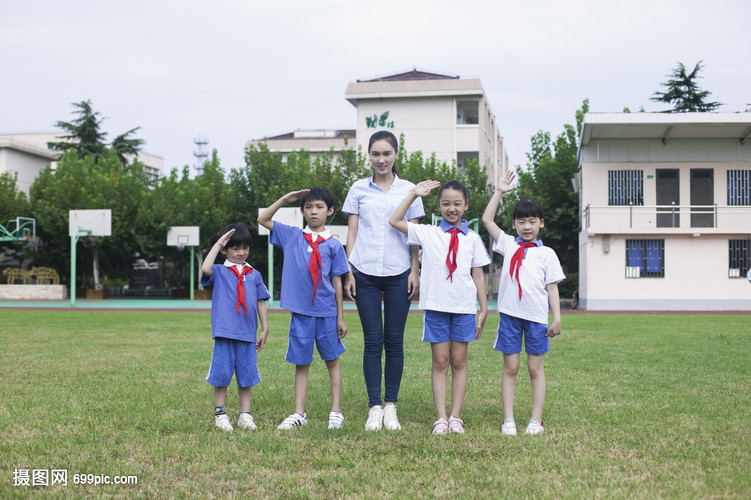 女老师和男女同学在操场上升国旗敬礼
