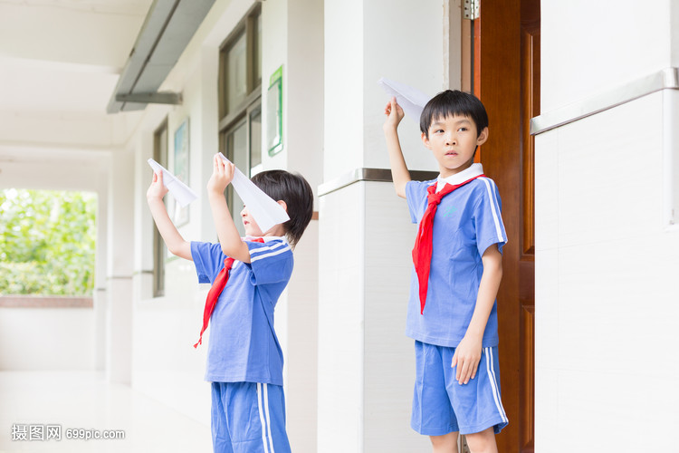 下课在走廊上玩飞机的小学生