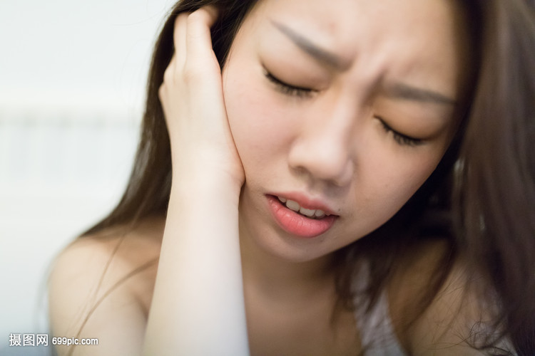 蛀牙牙痛坐在床上的女生