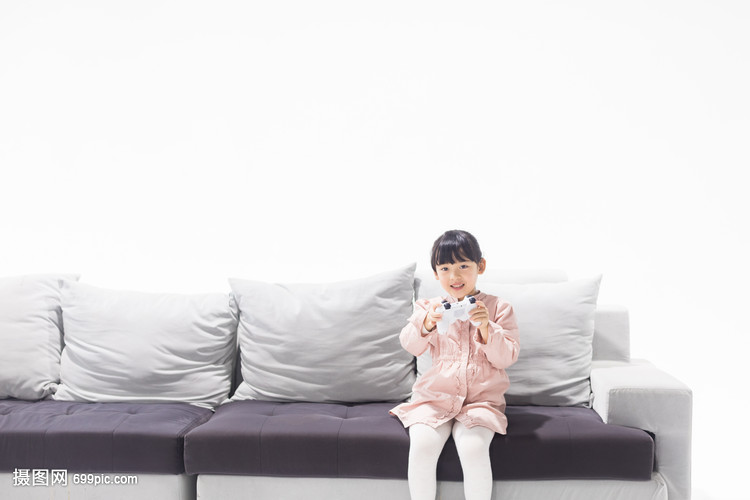 坐在沙发上玩游戏的小女孩