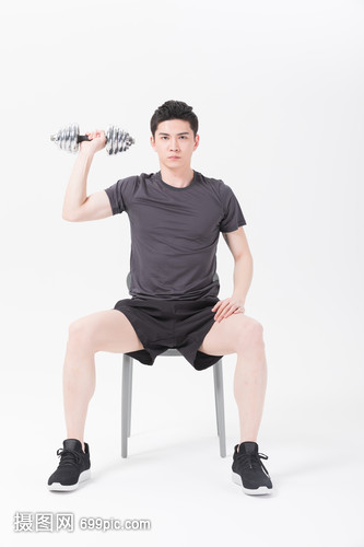 青年男性坐椅子上举哑铃健身
