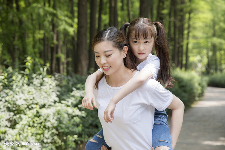 妈妈背着女儿在公园走路