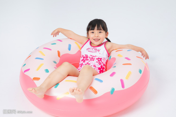 坐在游泳圈上的泳装小女孩